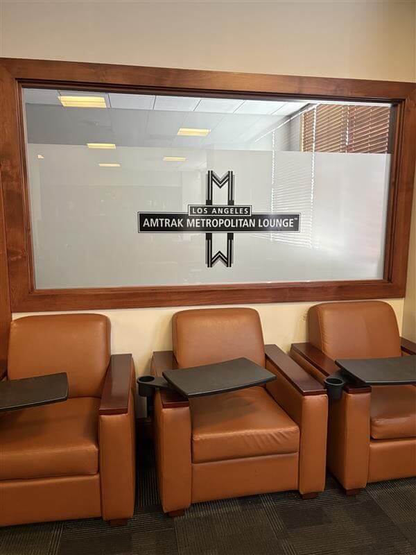 Chairs opposite the window with the logo "Amtrak Metropolitan Lounge"